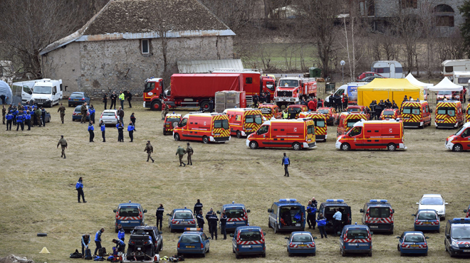 French emergency services workers (back) and members of the French gendarmerie gather in Seyne, south-eastern France, on March 24, 2015, near the site where a Germanwings Airbus A320 crashed in the French Alps. A German airliner crashed near a ski resort in the French Alps on March 24, killing all 150 people on board, in the worst plane disaster in mainland France in four decades. AFP PHOTO / BORIS HORVAT